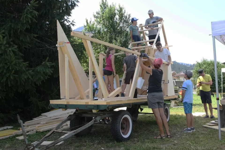 Mehrere Personen bauen die mobile Werkstatt auf einem Wagen.
