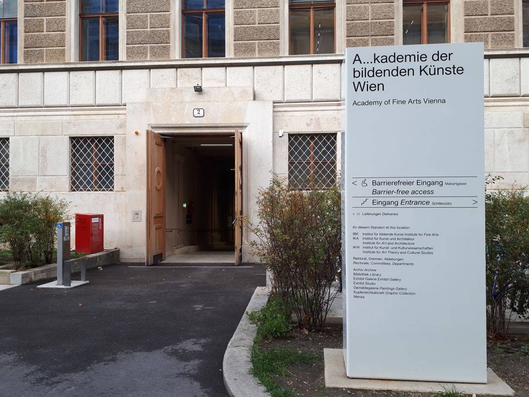 Tor beim Eingang Markartgasse, im Vordergrund Stele.